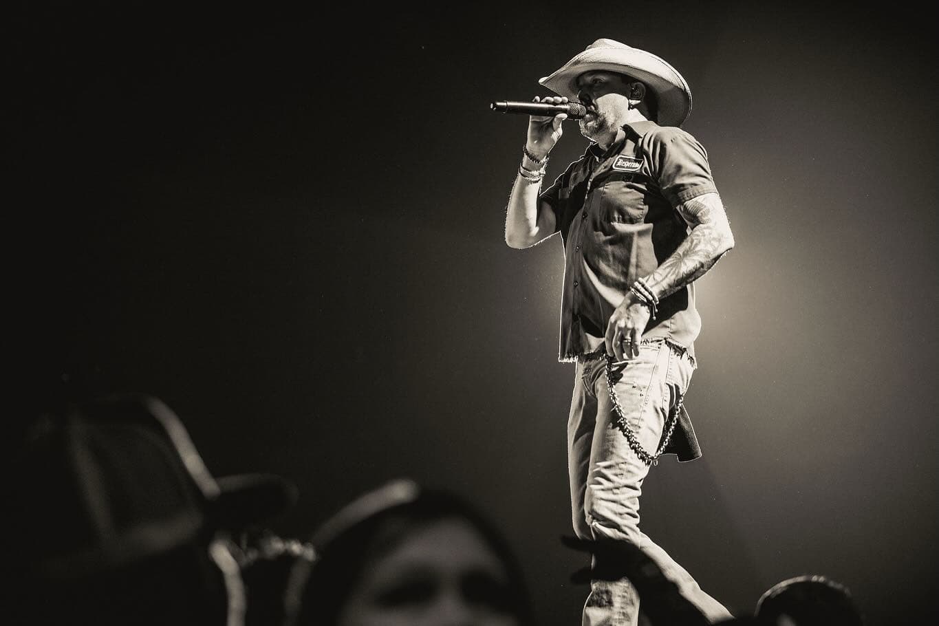 Jason Aldean and Luke Bryan standing together on stage, both wearing casual outfits and smiling at the audience.