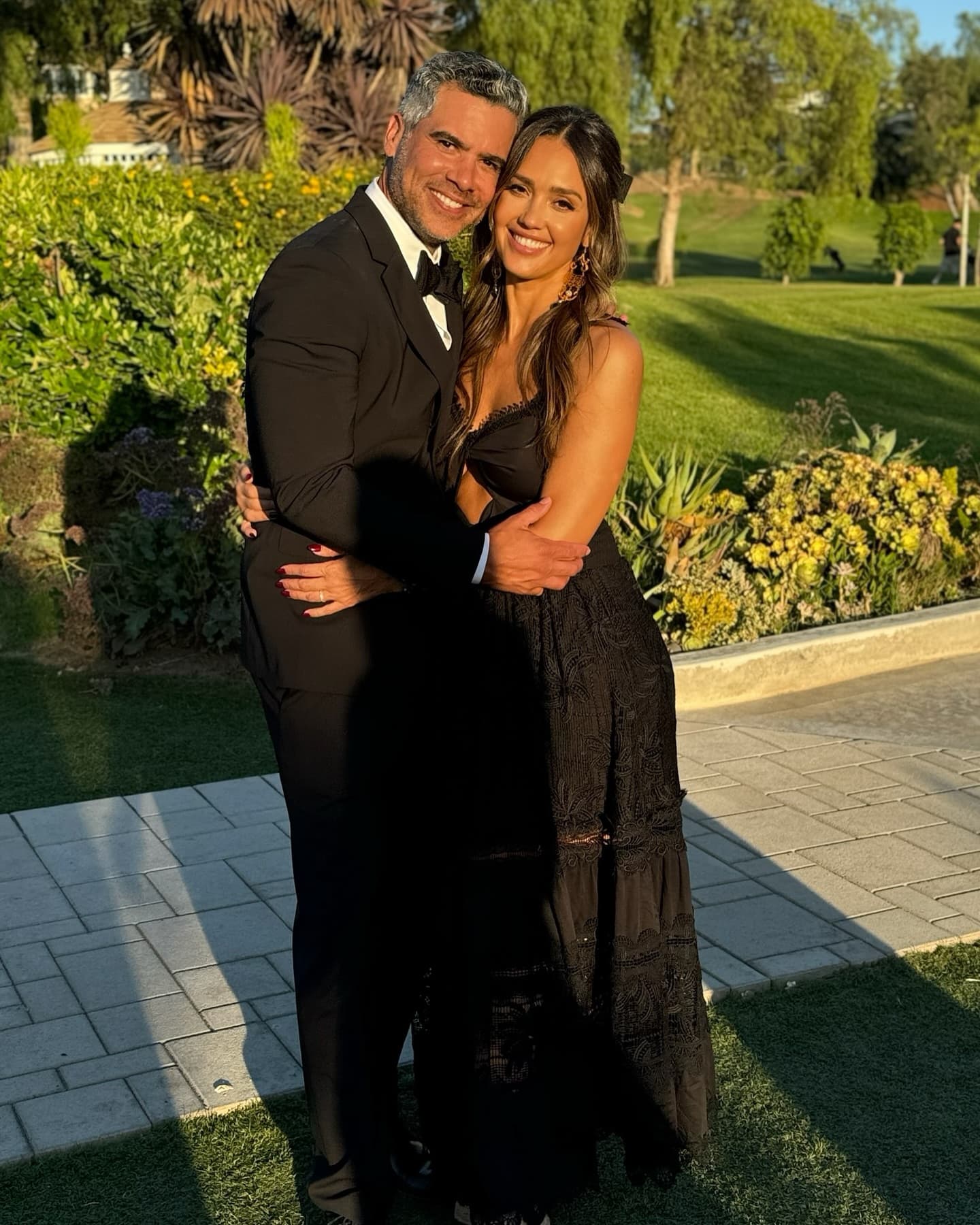 Jessica Alba in a casual outfit walking alongside Cash Warren in a relaxed setting, both looking contemplative.