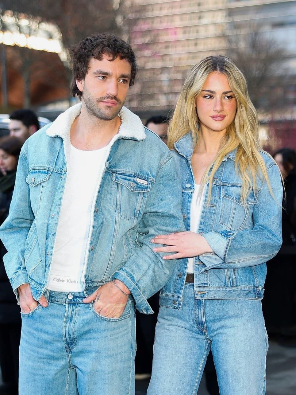Katey Sagal smiling at an outdoor event, wearing a colorful blouse and jeans, with son Jackson White beside her.